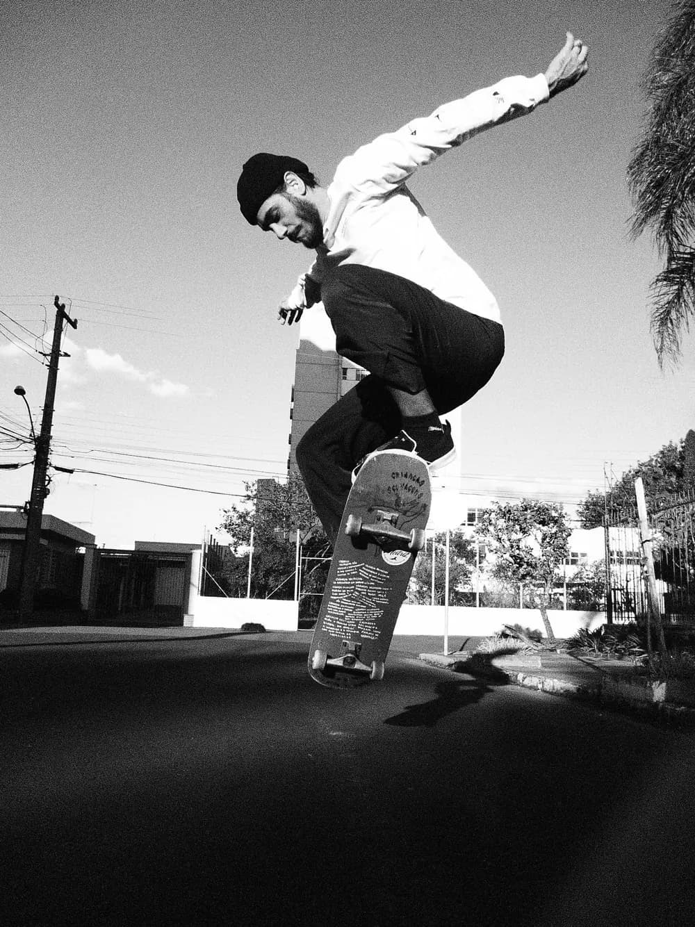 Skateboarder in mid-ollie against a clear sky